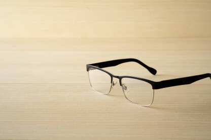 Crne naočale na drvenom stolu