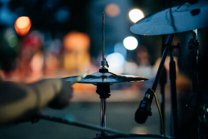 Bubnjar svira bubnjeve na live rock koncertu u noćnom ambijentu. Muzički instrument.
