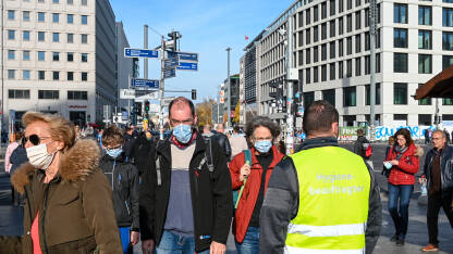 Berlin, Njemačka: Ljudi s maskom za lice hodaju ulicom. Covid-19 zaštita. Grupa ljudi s medicinskim maskama u gradu. Zaštita od epidemije korona virusa.