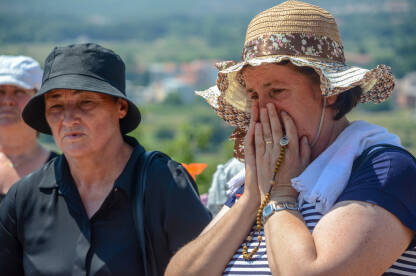 Grupa hodočasnika se moli na svetom mjestu. Hodočasnici u Međugorju, Bosna i Hercegovina.