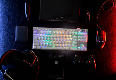Setup za gejming i dizajn sa tastaturom, tabletom, hard diskom, usb-om, mišem, džojstikom, notesom, slušalicama, vejpom osvjetljeno crvenim i plavim svijetlom