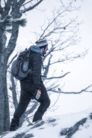 Planinar na snijegu, uspinje se uz brdo. Planinar se penje uz planinu tokom zime.