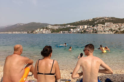 Ljudi sjede na plaži u Neumu Ljudi se kupaju i sunčaju u Jadranskom moru. Ljetni odmor. Na plaži u Neumu. Bosna i Hercegovina.