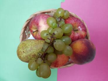 Voćni miks u pletenoj zdjeli (grožđe, kruška, jabuke i breskva)