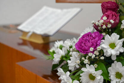 Cvijeće u crkvi. Ukrašeni oltar u katedrali. Biblija na oltaru.