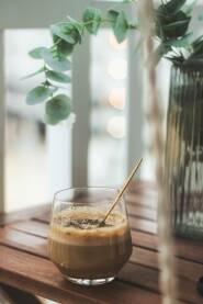Homemade espresso kava u staklenoj čaši sa zlatnom kašikom. Detalji ljetne večeri. Fokus je na detaljima, uz "soft look" i bokeh.