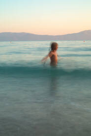 Djevojčica se kupa u Jadranskom moru u predvečerje.