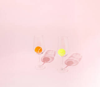 Žuta i narančasta tenis loptica u vinskim čašama.