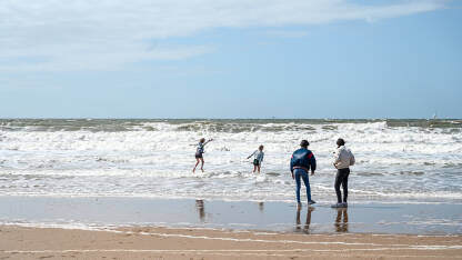 Ljudi se zabavljaju na plaži. Obala Sjevernog mora u Hagu. Turisti na pješčanoj plaži.