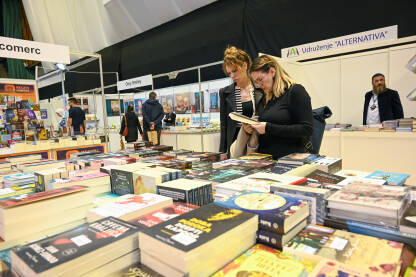 Posjetioci na sajmu knjiga. Ljudi biraju i pregledavaju knjige. Zbirka knjiga na štandu. Sarajevski sajam knjige.