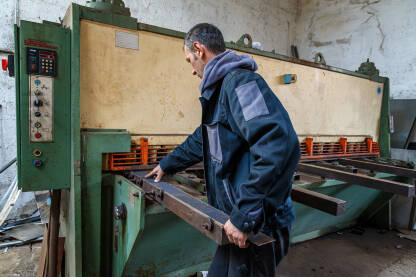 Radnici na industrijskoj presi za metal