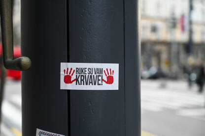 Naljepnica sa natpisom "ruke su vam krvave" u Beogradu. Naljepnica sa natpisom "ruke su vam krvave" u Beogradu. Studentski protesti u Beogradu, Srbija. Protesti izazvani korupcijom i neodgovornosti vlasti nakon pada nadstrešnice u Novom Sadu.