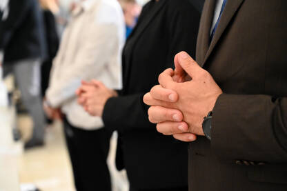 Prekrštene ruke vjernika u crkvi. Ljudi se mole u katedrali. Misa u crkvi.
