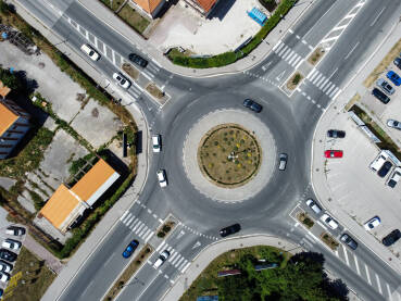 Kružni tok u gradu, snimak dronom. Automobili se kreću. Saobraćaj u  kružnom toku u gradu. Prijevoz.