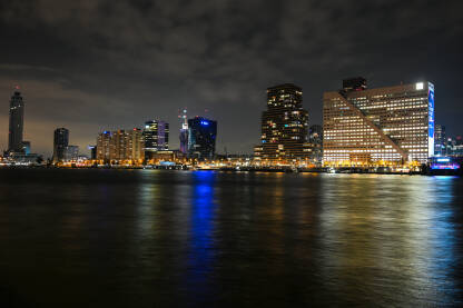 Roterdam, Nizozemska. Grad Rotterdam noću. Panoramski pogled na nebodere i svjetla na zgradama u gradu. Noćni panoramski snimak grada.