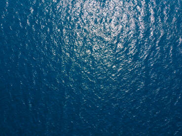 Morska površina, snimak dronom. Odraz sunca na površini vode.