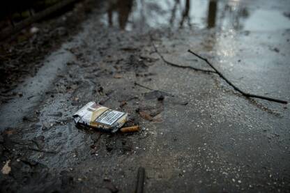 Kutija cigareta i opušak bačen na pod.