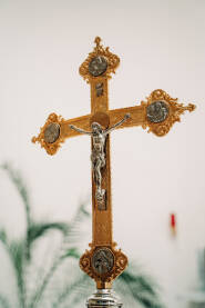 Ukrašeni, metalni, katolički križ sa likom Isusa Hrista. Detalj iz župnne crkve u Komušini.