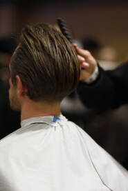 Barber povlači posljednje poteze na novoj modernoj muškoj frizuri.