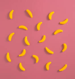 Banana gumeni bomboni na roze pozadini.