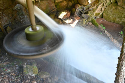 Duga ekspozicija vode koja pada na mlinski točak. Vodenica u prirodi za mljevenje žita.