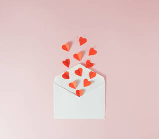 Crvena papirna srca u koverti.