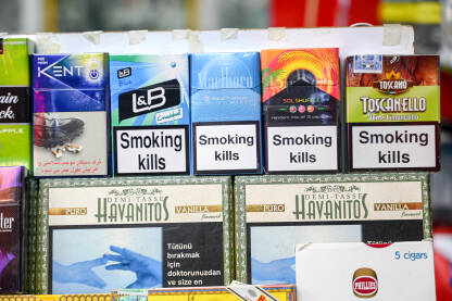 Kutije cigareta na policama u trgovini. Kutije cigareta na policama u trgovini. Polica za cigarete u prodavnici. Paketi cigareta sa upozorenjima. Duhan. Natpisi: Pušenje ubija.