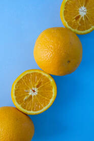 Sočna narandža na plavoj podlozi, koja je prerezana na pola.