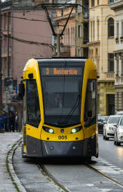 Moderan žuti tramvaj u Sarajevu na liniji broj 3 prema Baščaršiji, snimljen u urbanom gradskom okruženju.