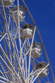 Bijeli panoramski točak sa kabinama i plavim nebom.