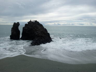 Stijena u moru na kojoj se vidi par ljudskih silueta. Arhitektura prirode.
