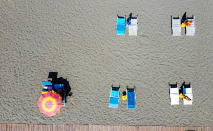 Suncobrani i ležaljke na plaži. Suncobrani i ležaljke na plaži. Ilustracija godišnjeg odmora, ljeta, sunčanja, turizma i putovanja.