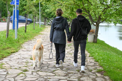 Zaljubljeni par šeta sa psom. Mladić i djevojka.