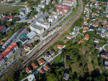 Voz prolazi kroz naselje, snimak dronom. Tereni voz na šinama u gradu. Transport željeznicom.