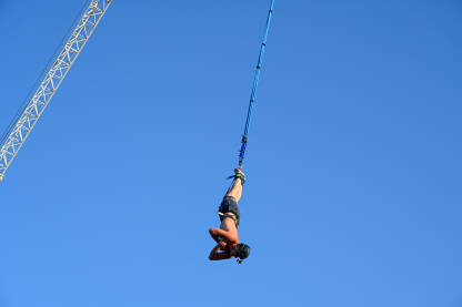 Bungee jumping. Mladić skače bungee jumping. Skok s  užetom. Čovjek se zabavlja Ekstremni sport.