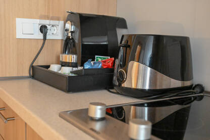 Toster i aparat za espresso kafu na radnoj površini u kuhinji. Manji kućanski aparati.
