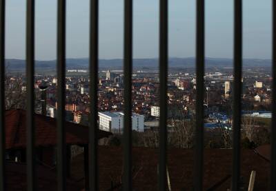 Pogled na grad sa visine kroz crnu metalnu ogradu