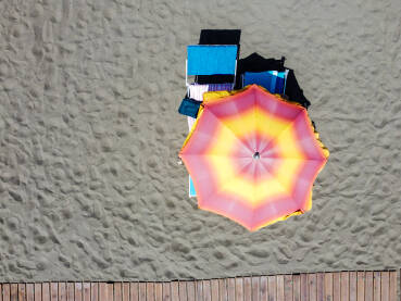 Šareni suncobran i ležaljka na plaži. Šareni suncobran i ležaljka na plaži. Ilustracija godišnjeg odmora, ljeta, sunčanja, turizma i putovanja.