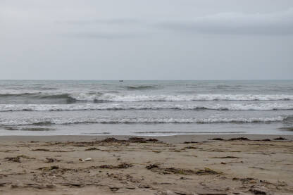 Pješčana plaža tokom nevremena. Kiša na moru. Prljava plaža posle oluje.
