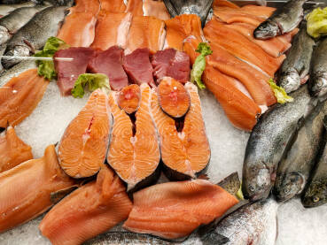 Svježa riba i riblji fileti na prodaji u supermarketu. Pastrmka, tuna, orada i losos na ledu.