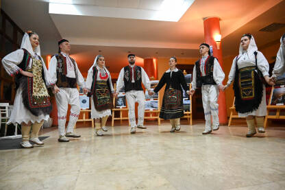 Muškarci i djevojke u tradicionalnoj narodnoj nošnji plešu. Tradicionalni ples. Kolo je južnoslovenski kolo koji se izvodi na priredbama.