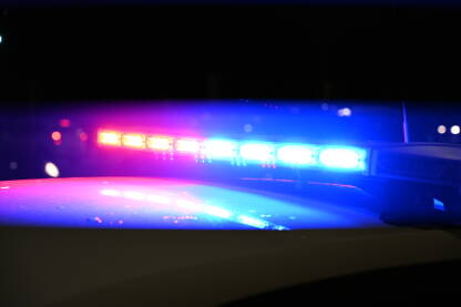 Policijska svjetla bljeskaju noću. Automobilska nesreća. Mjesto zločina. Plava i crvena svjetla trepere na patrolnom automobilu.