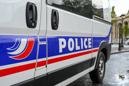 Policijski automobil na ulici. Bočni pogled na policijski automobil s natpisom "Policija". Policijsko patrolno vozilo parkirano na ulici u Parizu, Francuska.