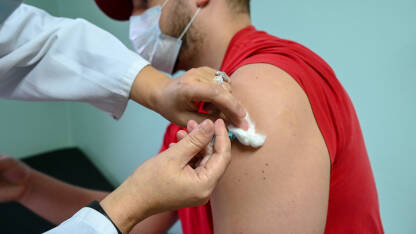 Čovjek prima cjepivo u rame. Cijepljenje protiv Covida. Liječnik pacijentu ubrizgava antivirusno cjepivo Covid-19. Cijepljenje protiv koronavirusa. Imunizacija građana.