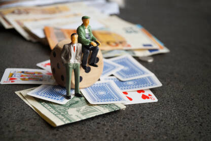 Ilustracija kockara, figure ljudi sa kockom, kartama i novcem.