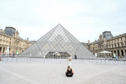 Pariz, Francuska: Ljudi ispred muzeja Louvre. Staklene piramide ispred poznatog muzeja. Turisti istražuju grad.