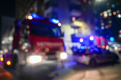 Zamućena fotografija vatrogasnog vozila i vatrogasaca tokom intervencije.