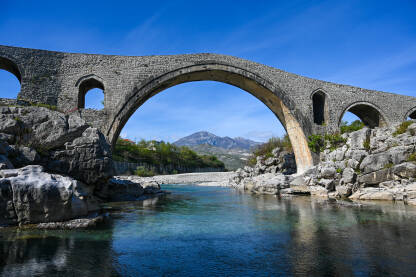 Stari kameni most iznad rijeke. Mesi most na rijeci Kir, Skadar, Albanija. Stari kameni most iznad rijeke. Voda teče ispod mosta. Mesi most na rijeci Kir, Shkoder, Albanija, sagrađen u 18 vijeku. Otomanska arhitektura. Turistička atrakcija.