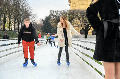 Ljudi se kližu na ledu. Mladi ljudi na klizaljkama. Advent u Zagrebu, Hrvatska.