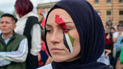 Žena sa palestinskom zastavom na licu. Protest podrške palestinskom narodu. Protest solidarnosti. Ljudi na demonstracijama u Sarajevu, BiH. Podrška narodu Gaze.